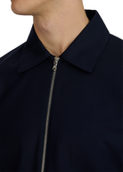 Close-up of a navy blue jacket with a zipper on a white background