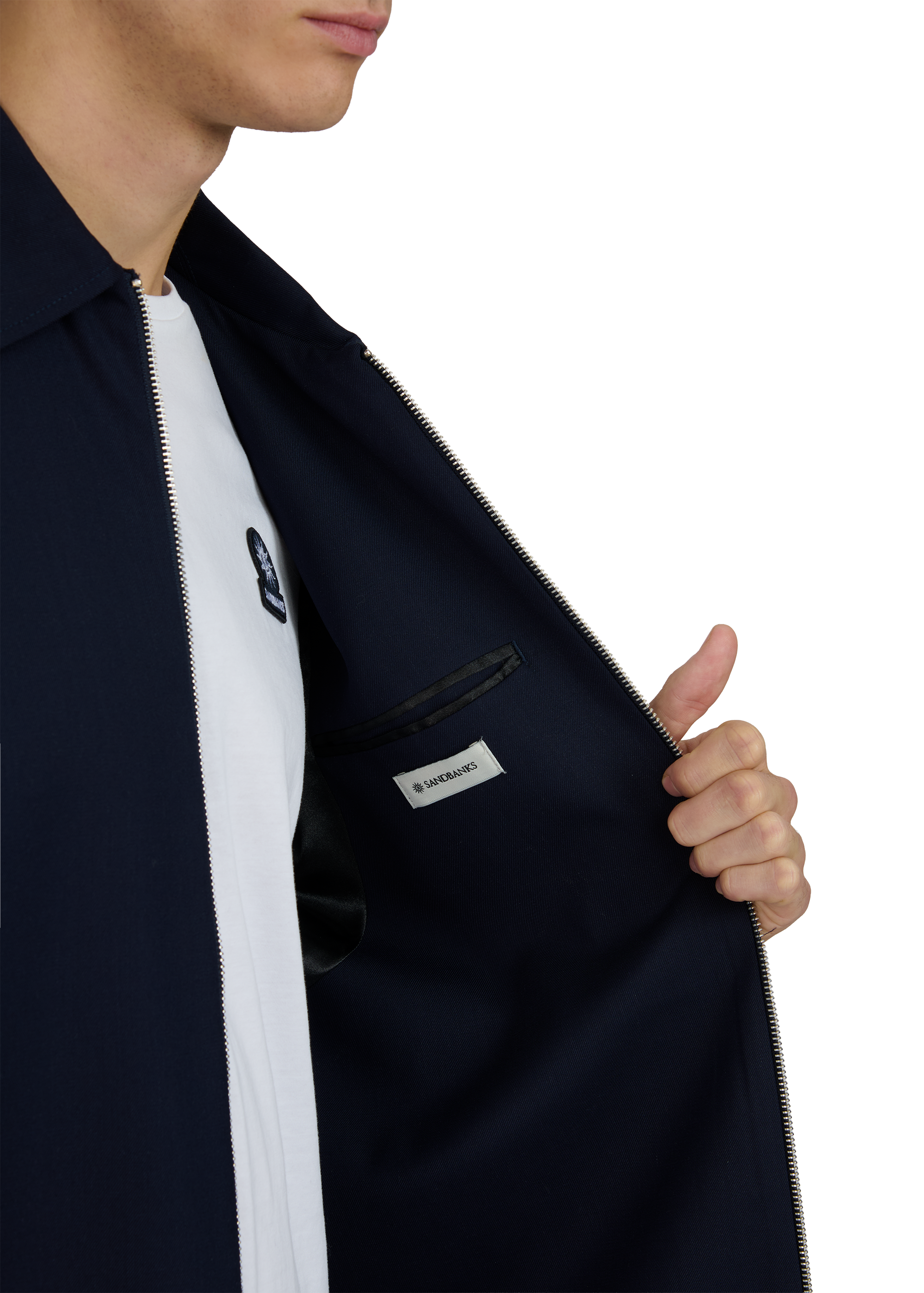 Person wearing a navy jacket with a brand logo on a white background