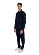 Man wearing a navy tracksuit with a white background
