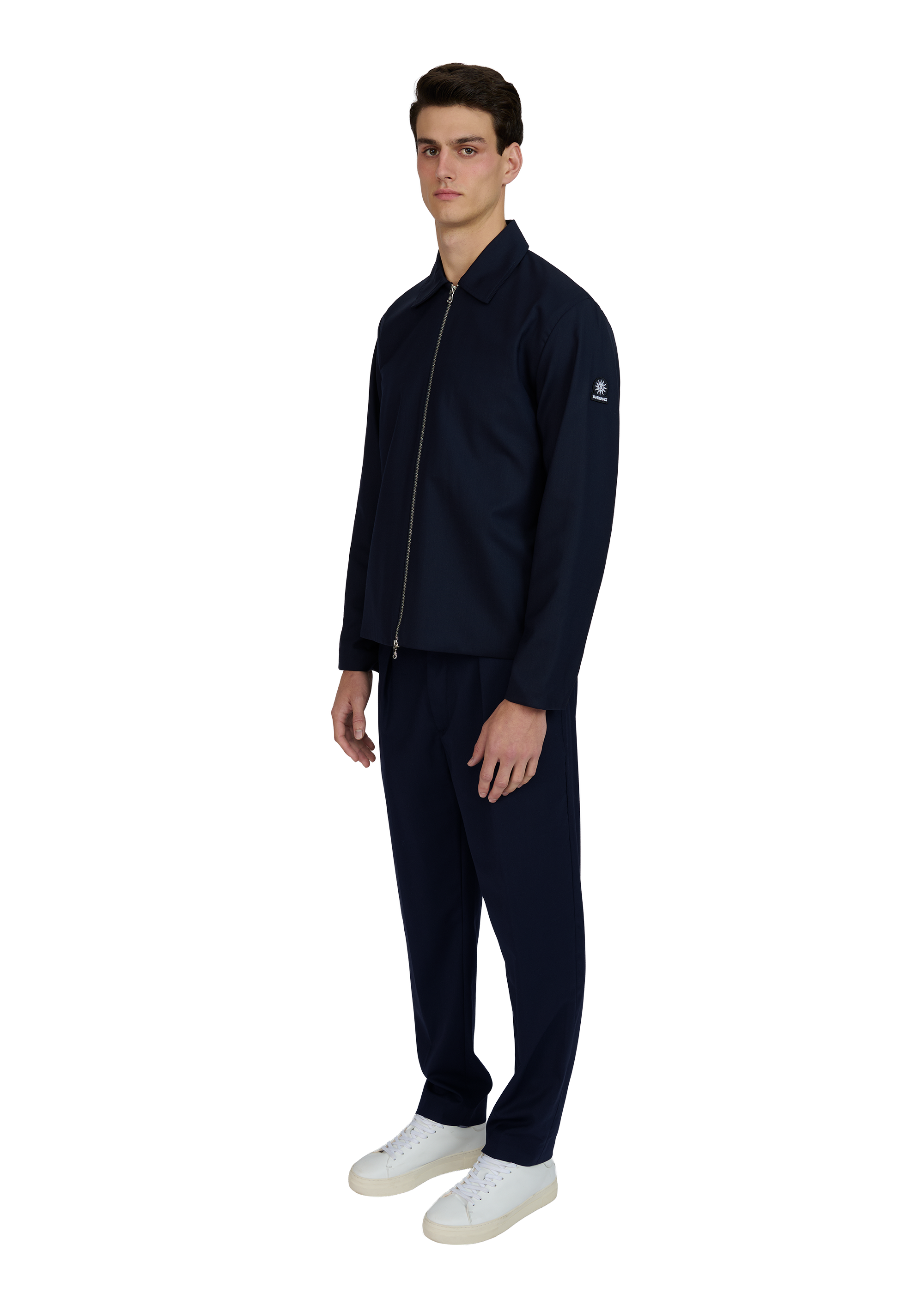 Man wearing a navy tracksuit with a white background
