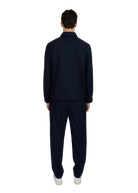 Person wearing a navy tracksuit on a white background