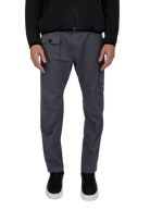 Person wearing gray pants with a black jacket on a white background