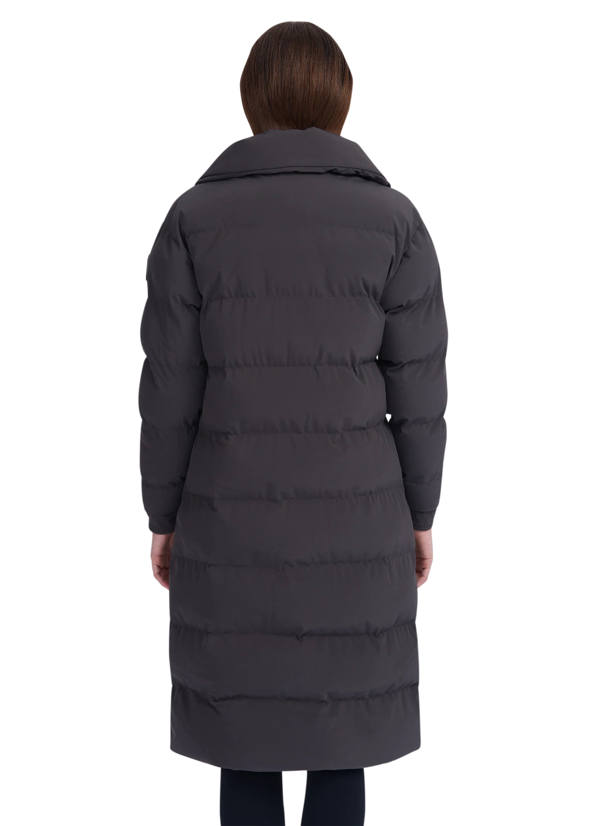 Person wearing a long dark gray puffer coat on a white background