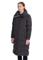 Woman wearing a long black puffer coat with brand logos on a white background