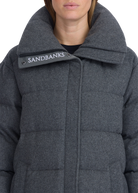 Close-up of a person wearing a gray Sandbanks coat with a visible brand logo.