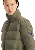 Person wearing a green puffer jacket with a brand logo on a white background