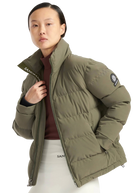 Person wearing a green puffer jacket with a brand logo on a white background
