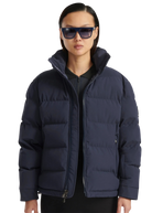 Person wearing a navy blue puffer jacket on a white background