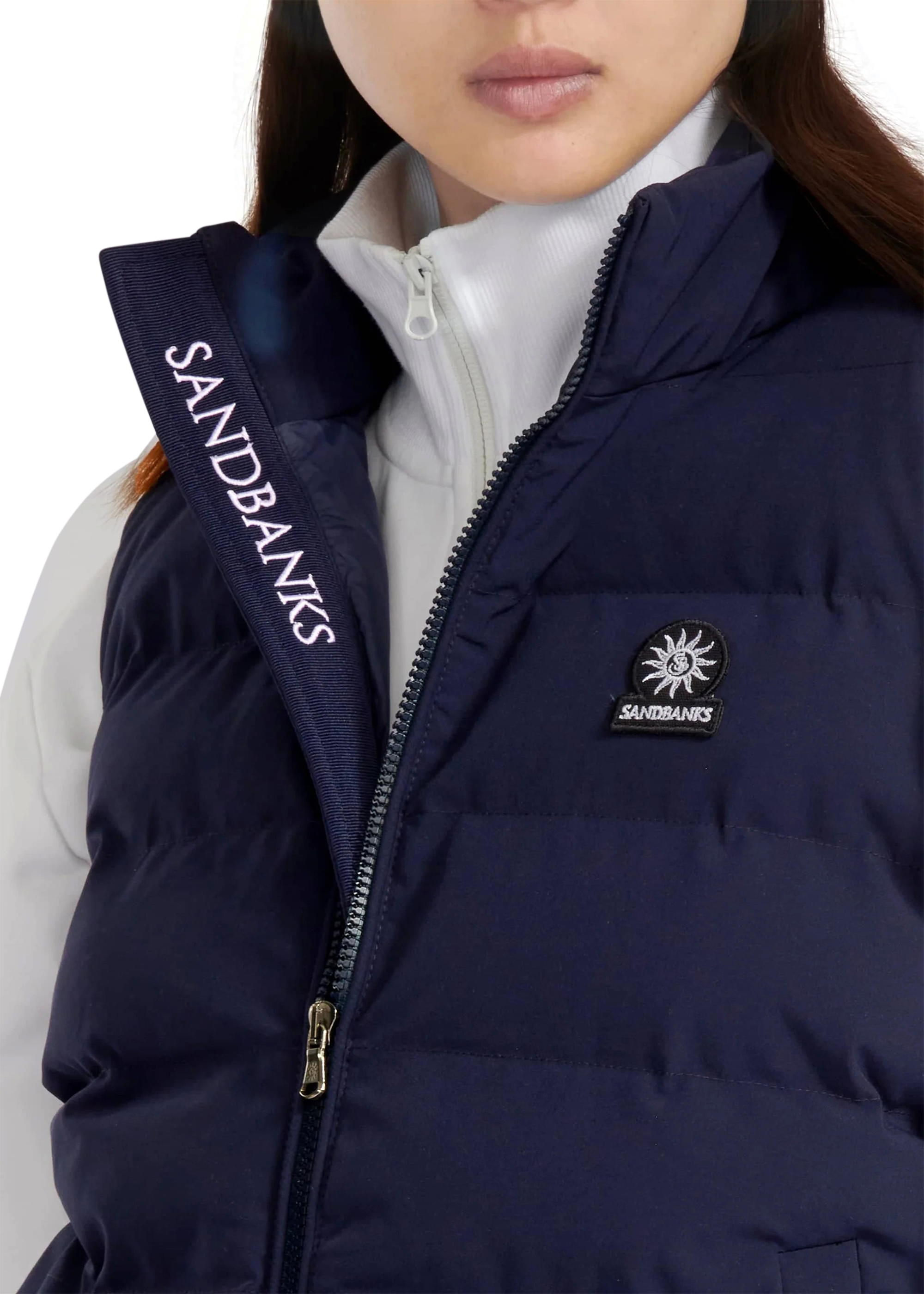 Navy puffer vest with Sandbanks branding on a white background