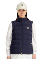Person wearing a navy puffer vest over a white shirt with a white cap.