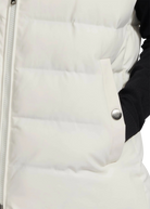 Close-up of a white puffer jacket with a zipper and button detail.