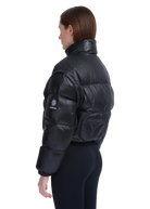Person wearing a black puffer jacket with a visible brand logo on a white background