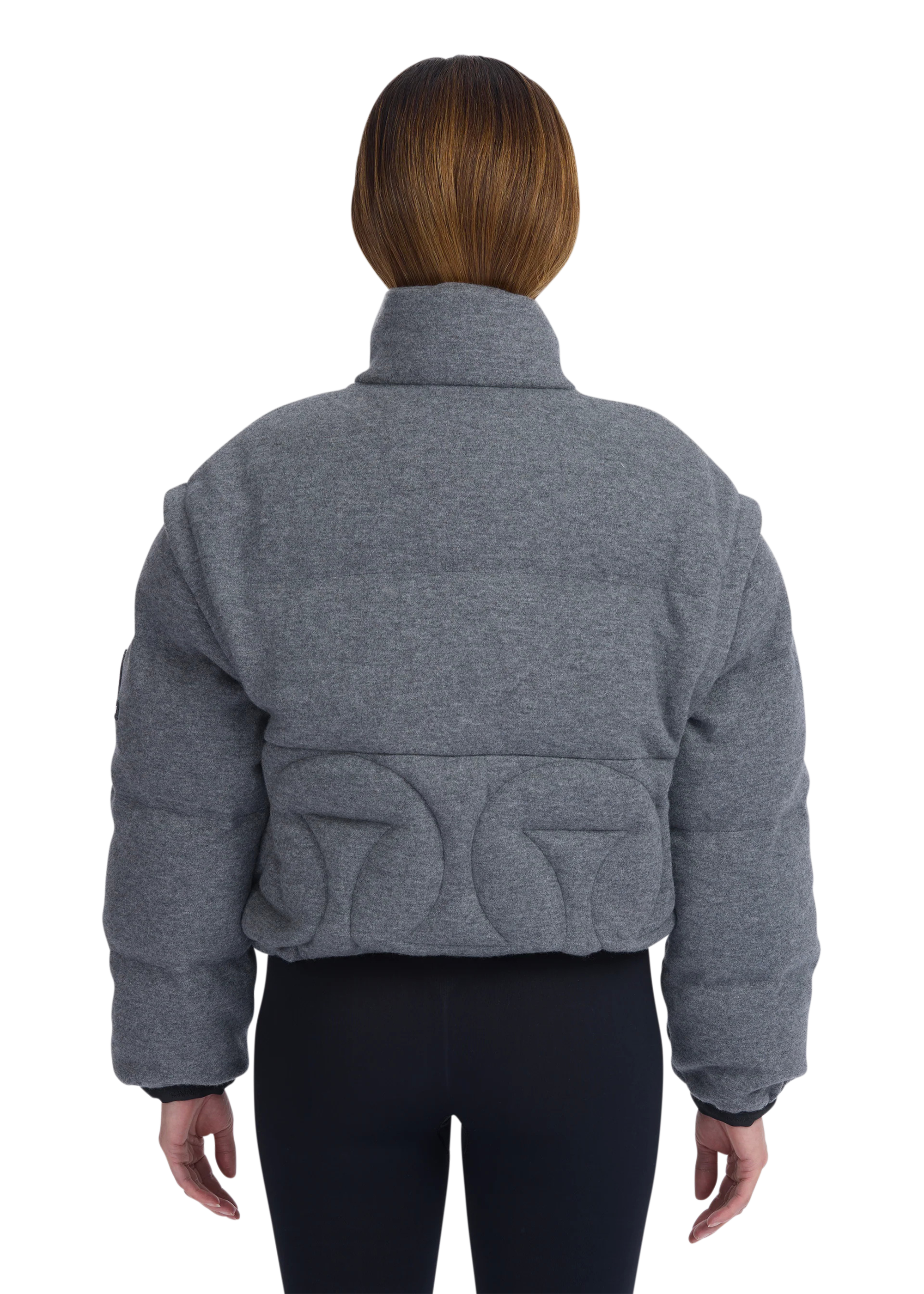 Person wearing a gray quilted jacket on a white background