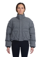 Person wearing a gray quilted jacket on a white background