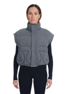 Woman wearing a gray quilted vest on a white background