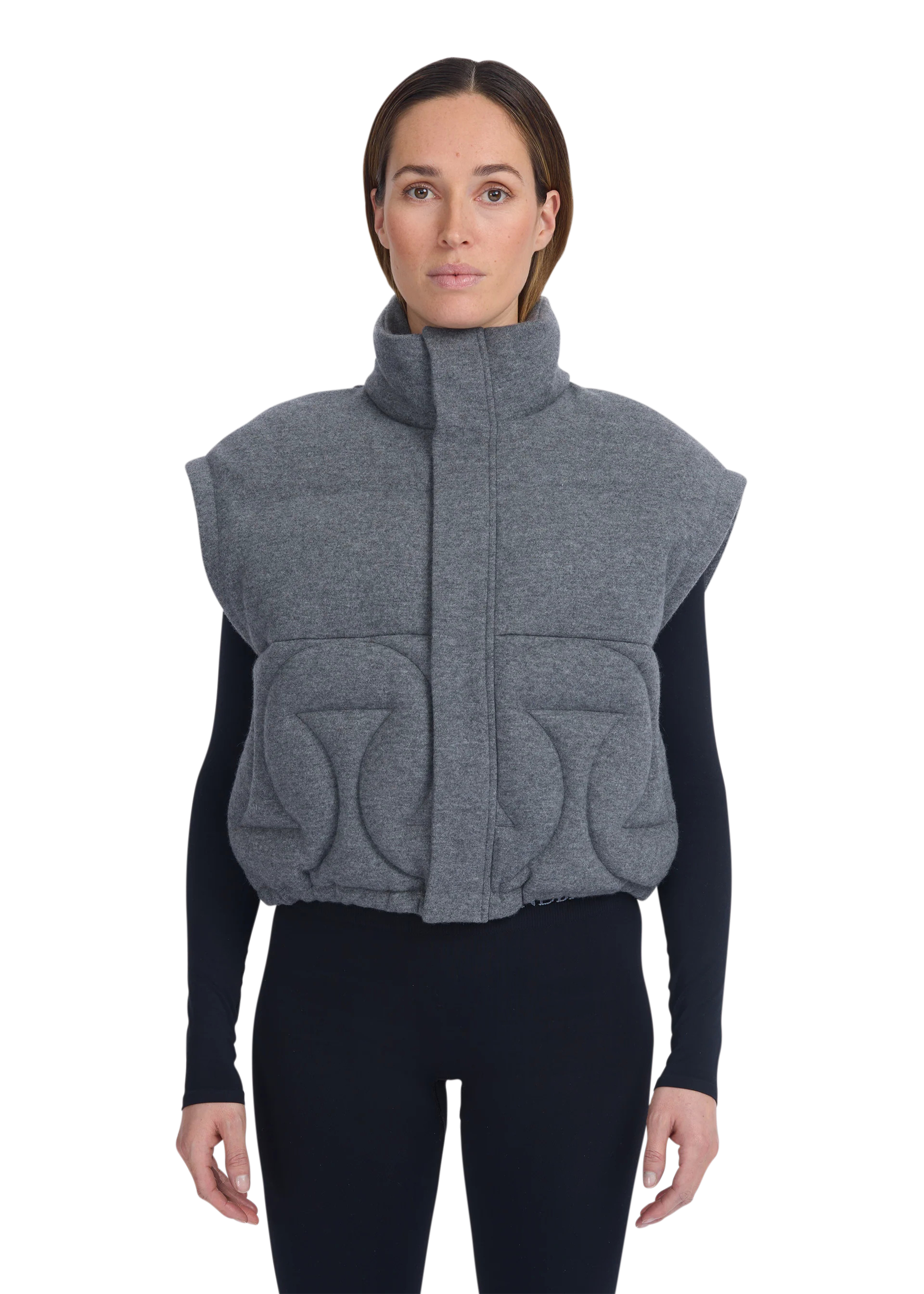 Woman wearing a gray quilted vest on a white background