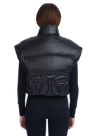 Black puffer vest worn by a person on a white background