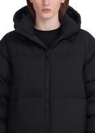 Person wearing a black puffer jacket with a hood on a white background