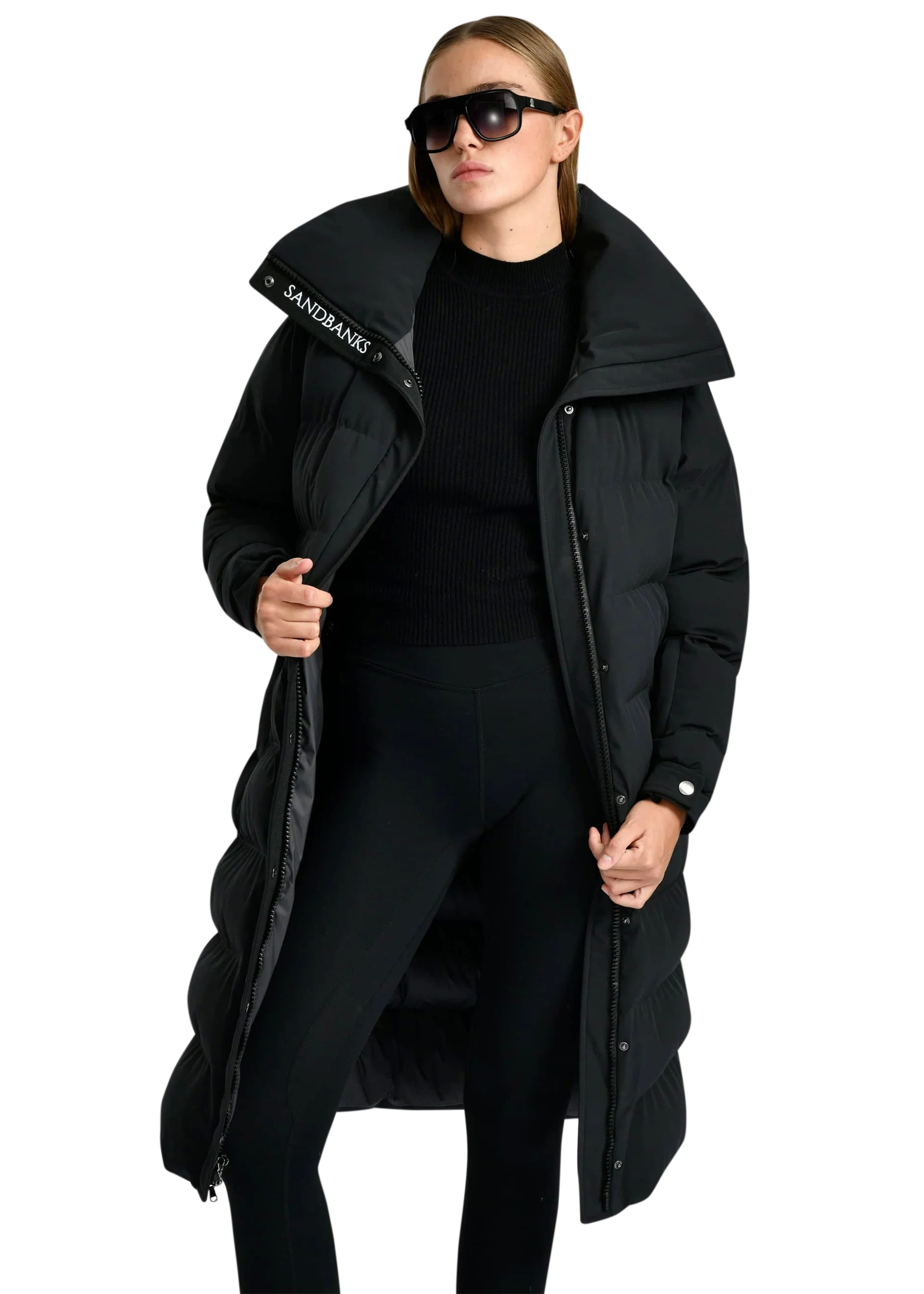 Person wearing a long black puffer coat with a brand logo on a white background