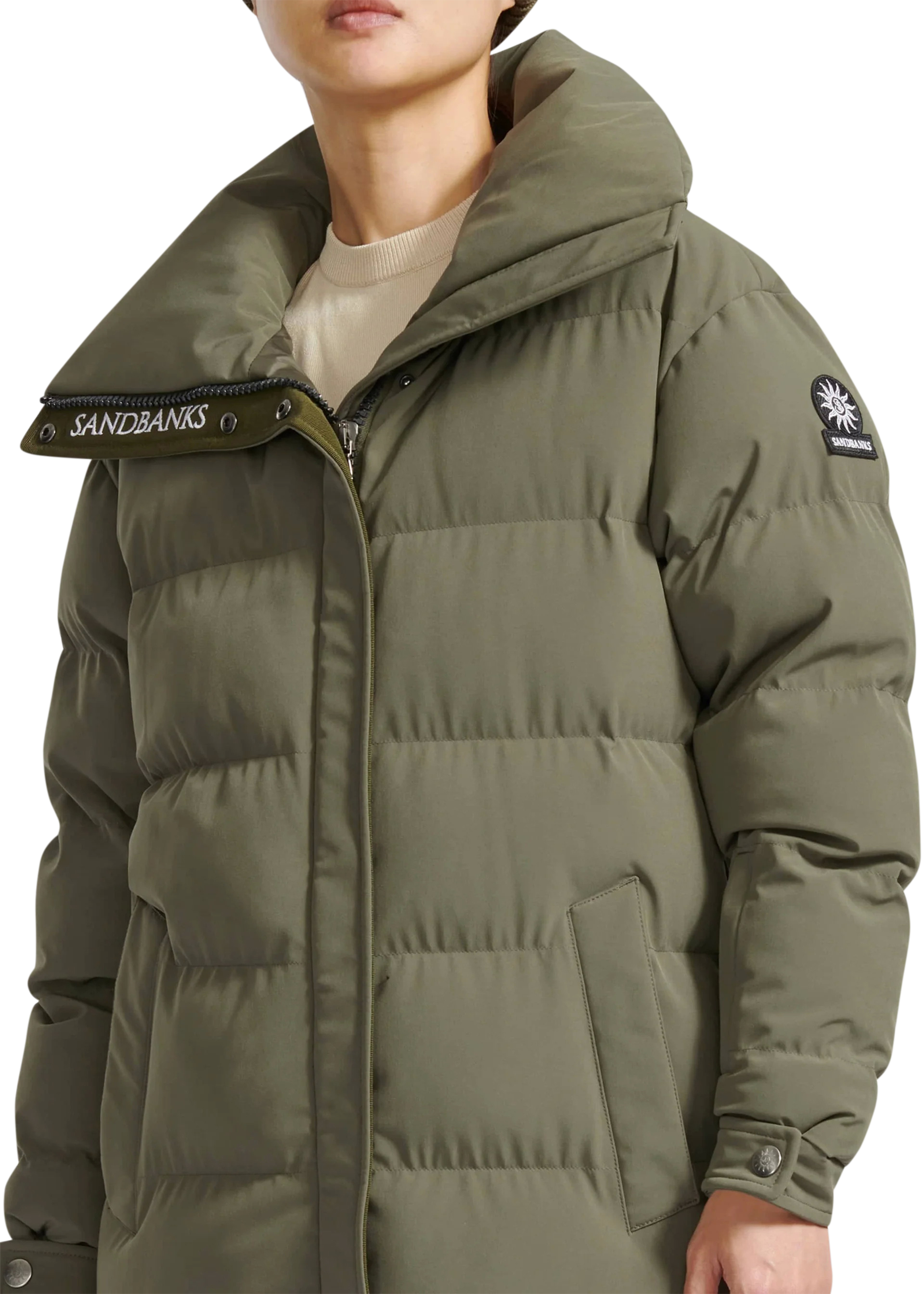Person wearing a green puffer jacket with visible branding on a white background