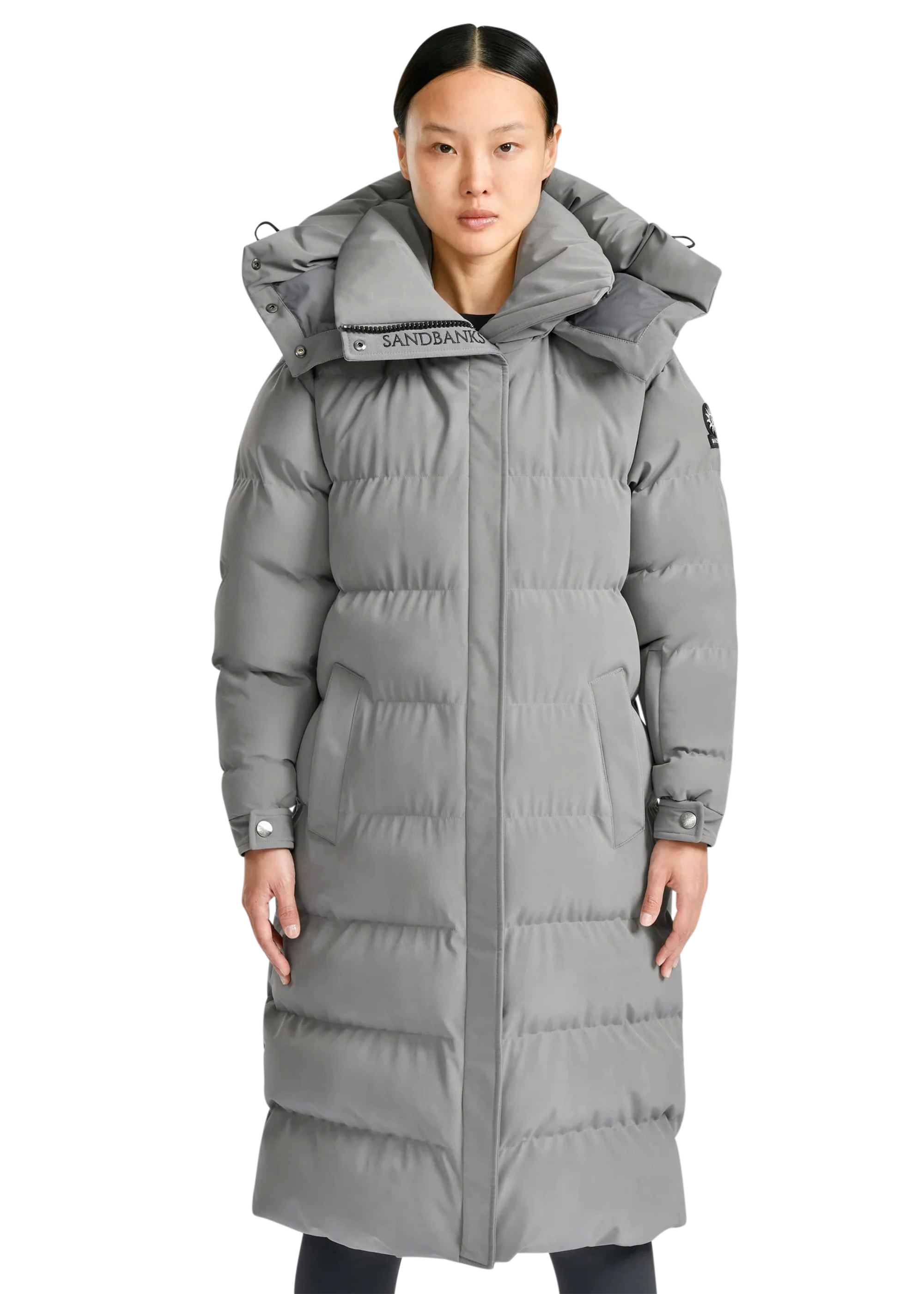 Woman wearing a grayダウン jacket on a white background