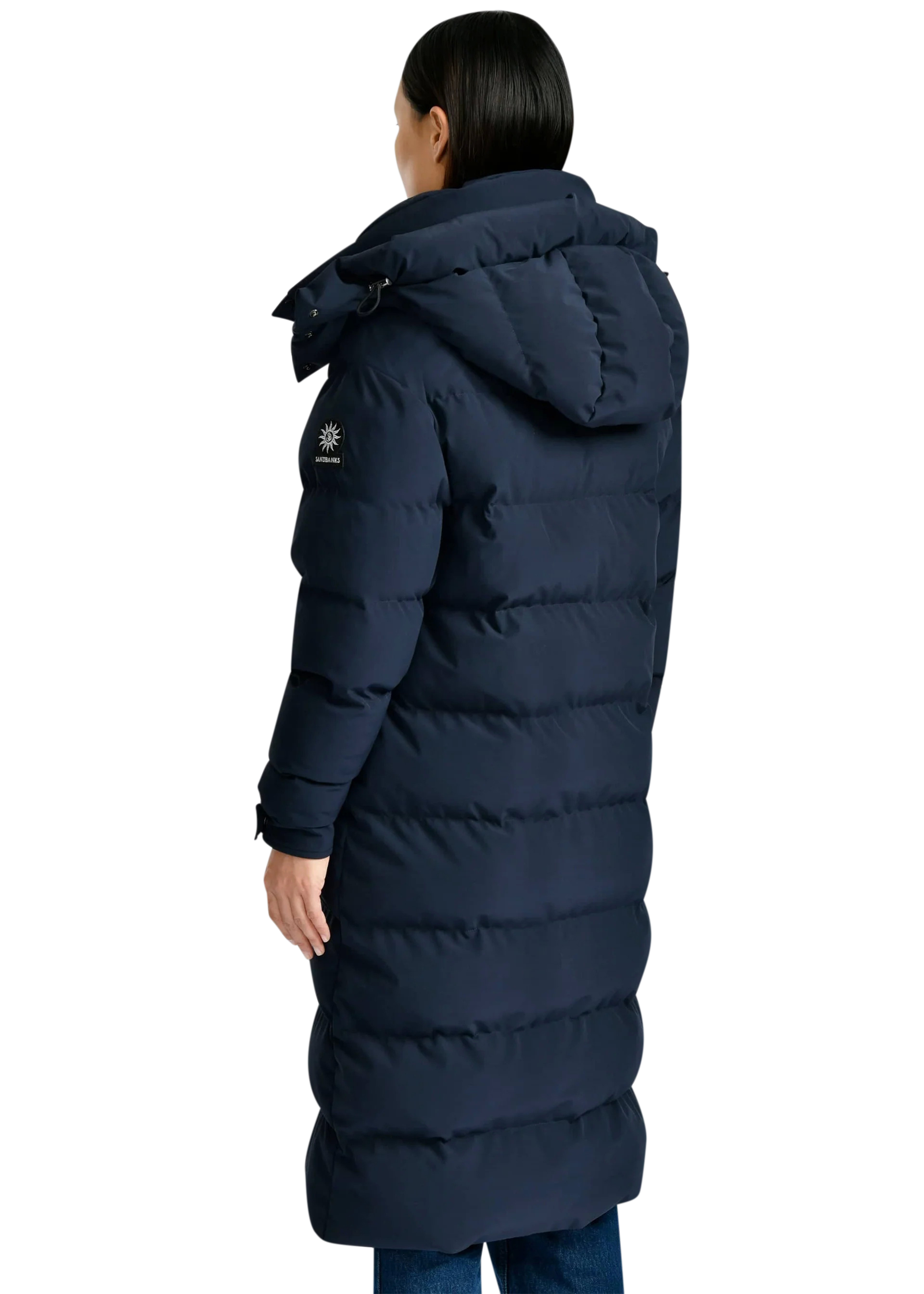 Person wearing a long navy blue puffer coat on a white background