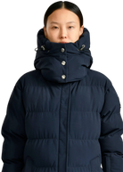 Person wearing a navy blue puffer jacket on a white background