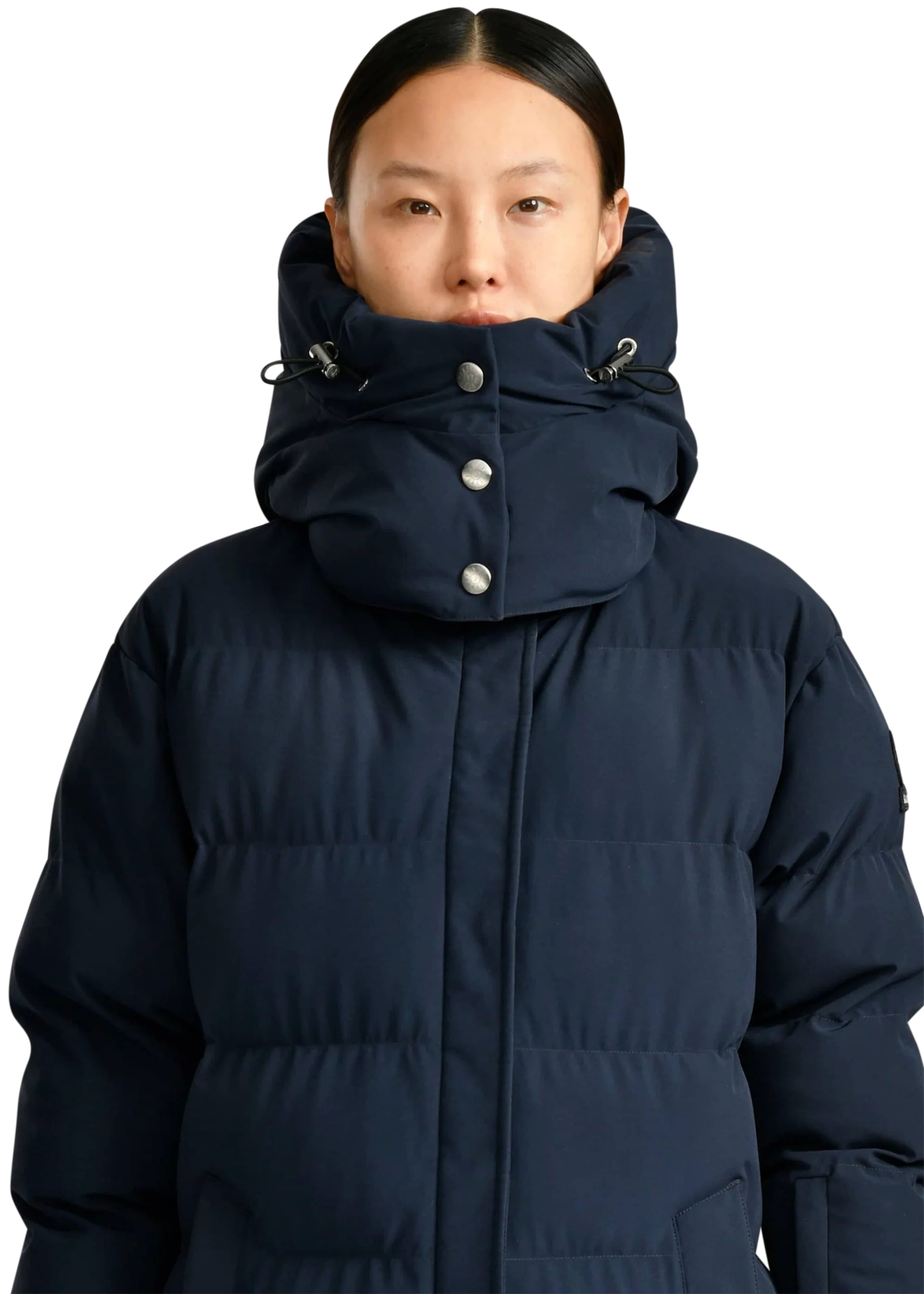 Person wearing a navy blue puffer jacket on a white background