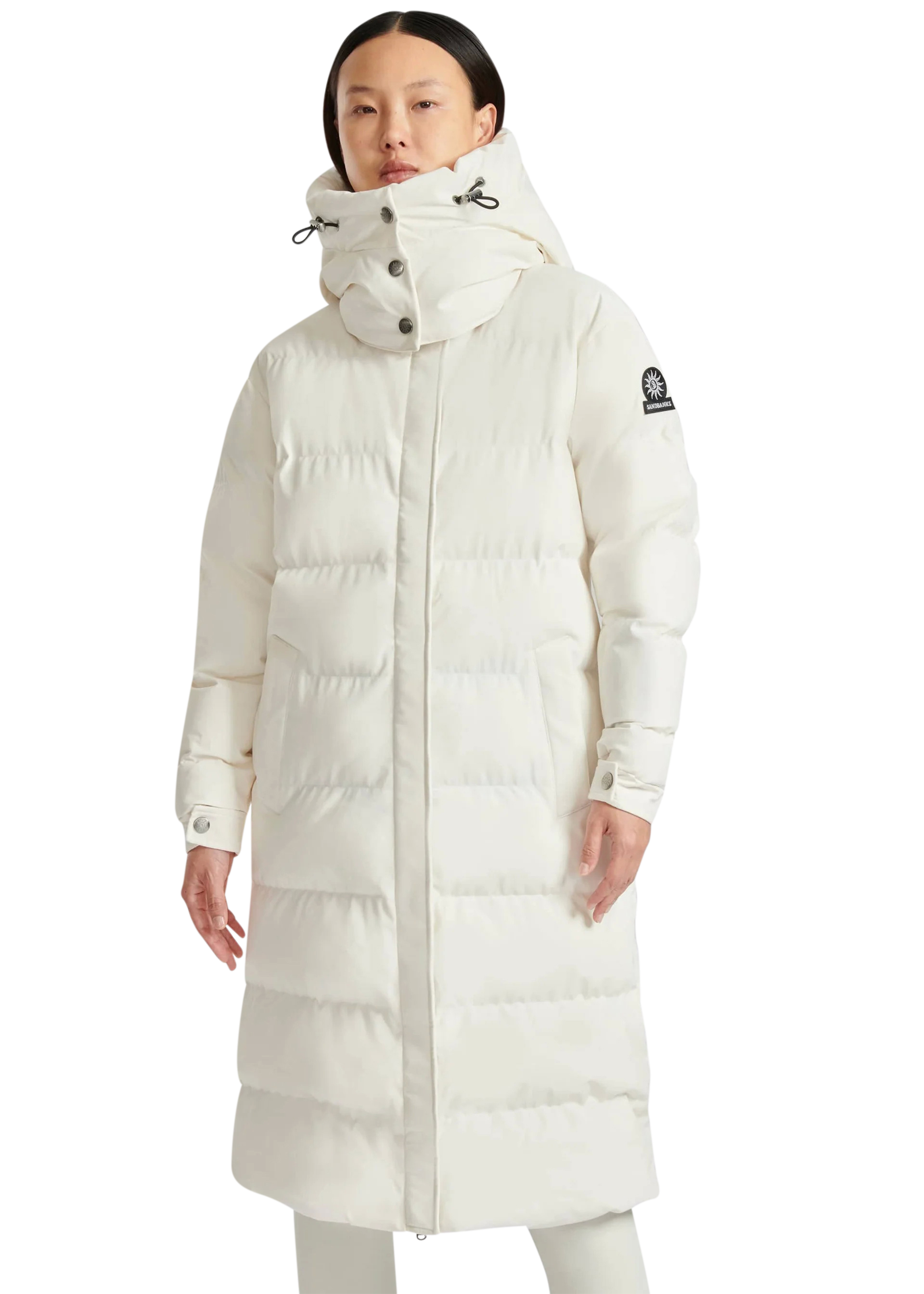 Woman wearing a long white puffer coat on a white background