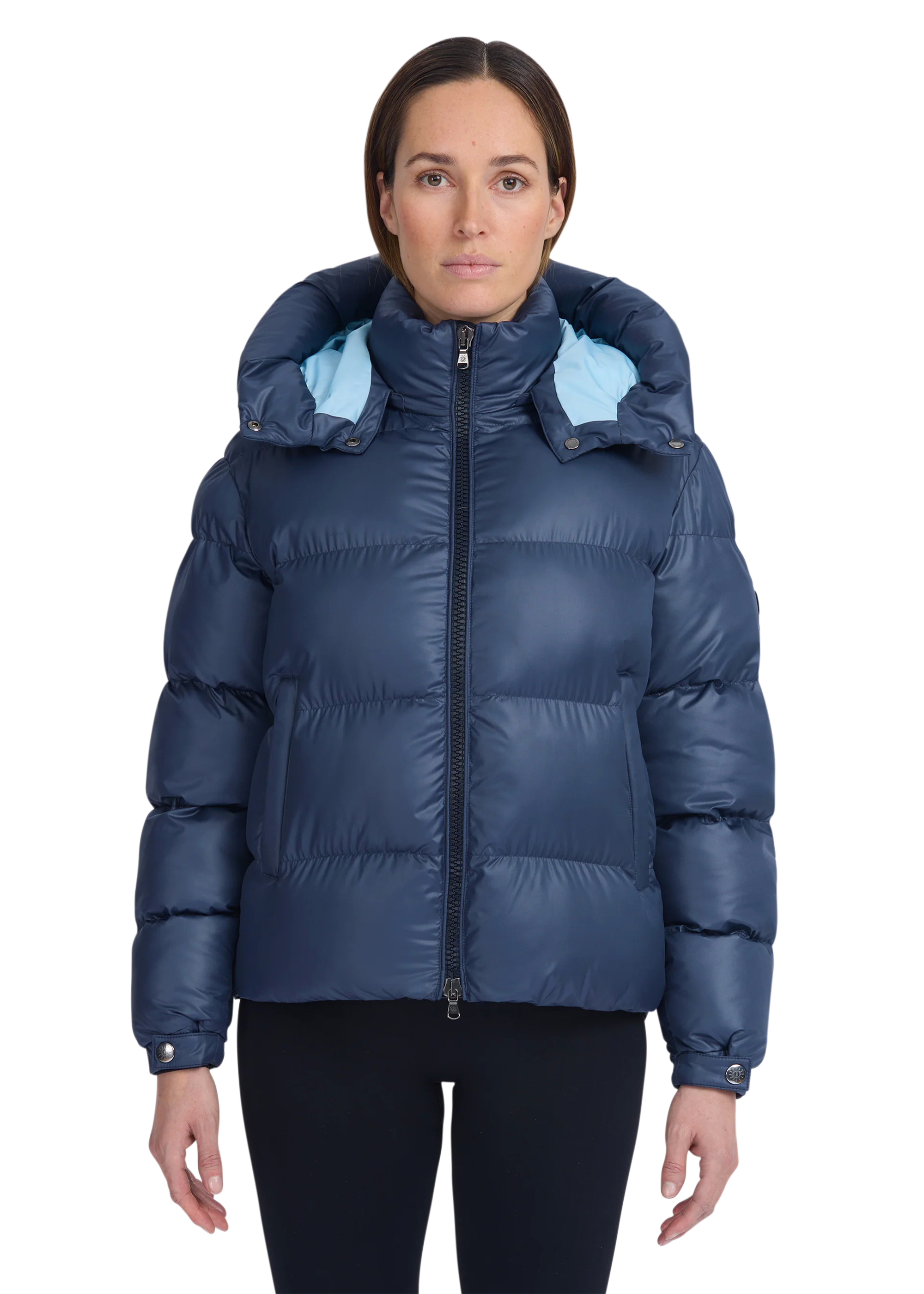 Woman wearing a blue puffer jacket with a hood on a white background