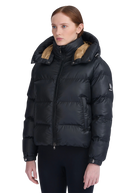 Woman wearing a black puffer jacket with beige lining on a white background