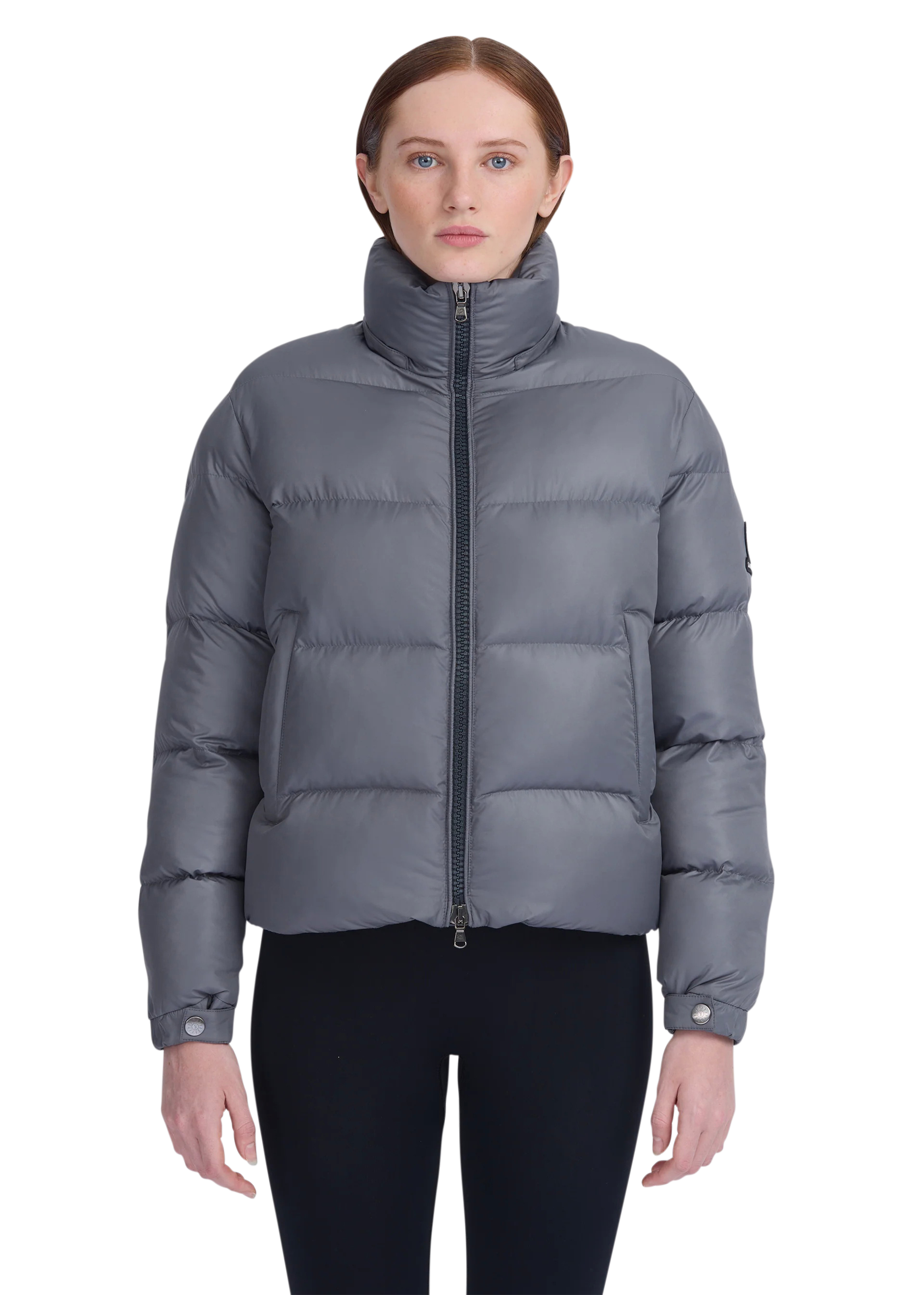 Woman wearing a gray puffer jacket on a white background
