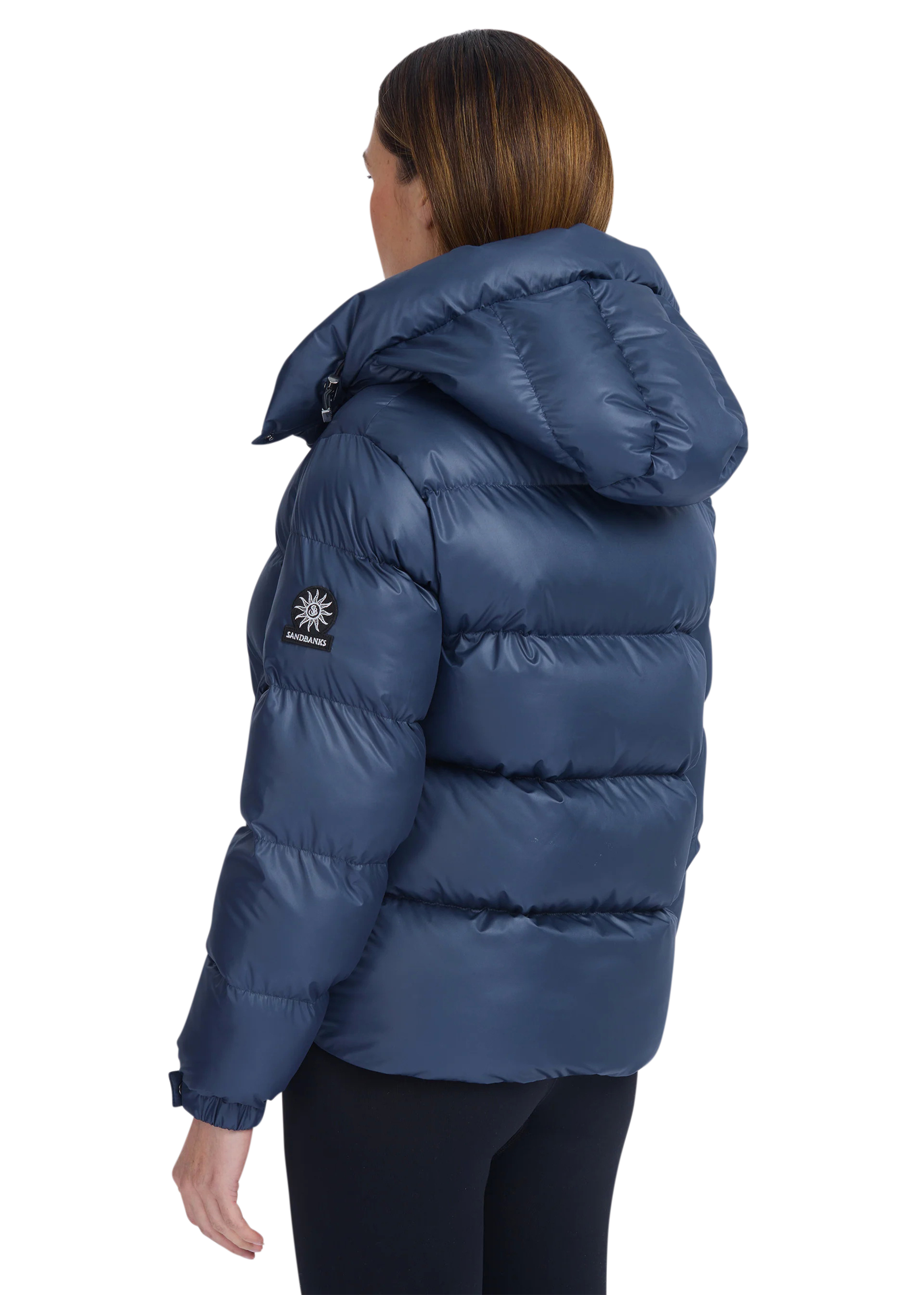 Person wearing a blue puffer jacket with a visible brand logo on a white background