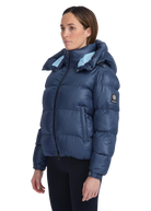 Woman wearing a blue puffer jacket with a brand logo on a white background