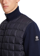 Navy puffer vest worn by a person with a brand logo on a white background