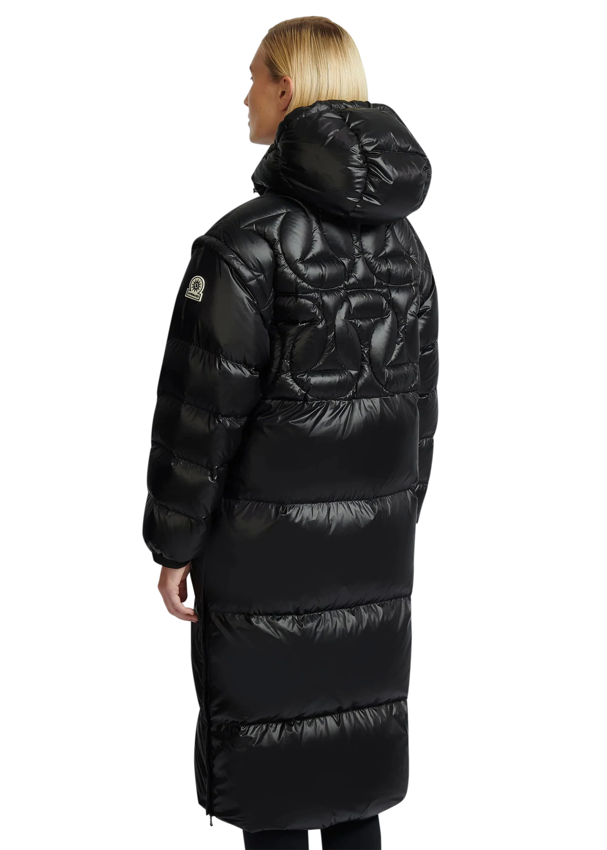 Person wearing a long black puffer coat on a white background